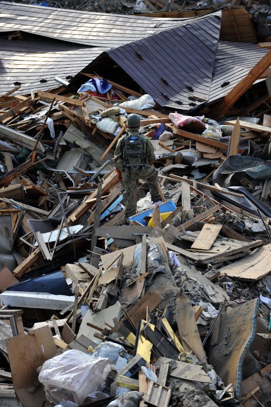 うずたかく積み上げられたがれきの上に立つ自衛隊員。憲法に緊急事態条項を新設すれば、救助活動などは円滑に進むというのか=岩手県宮古市で2011年4月3日、大西岳彦撮影
