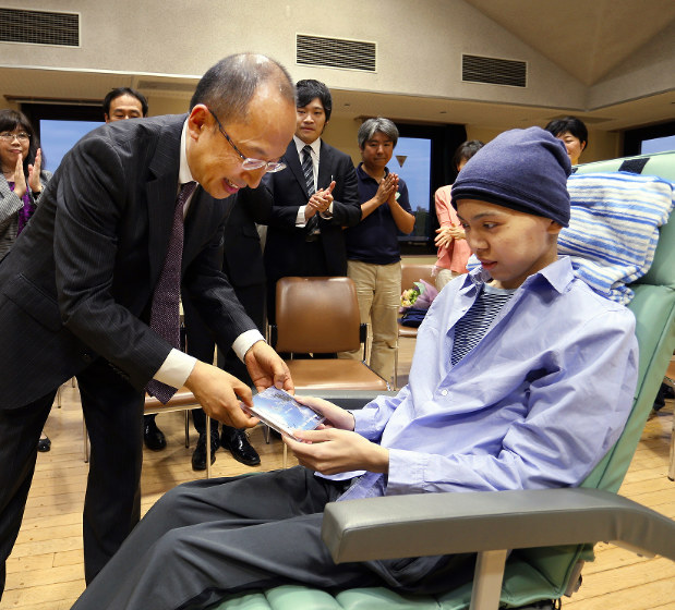 昨年5月、三谷さんからCDを受け取る旭さん(右)=神奈川県鎌倉市で、小出洋平撮影