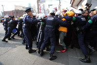 Police officers subdue local residents attempting to protest against a group of hate speech demonstrators, in Kawasaki's Kawasaki Ward in this Jan. 31, 2016 file photo. (Mainichi)