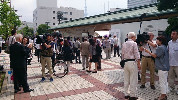 総会が始まる前、報道陣の取材を受ける東芝の株主たち=今沢真撮影