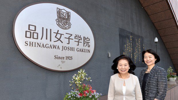 品川女子学院の入り口に立つ、いけばな作家の州村衛香さん(左)と同学院の漆紫穂子校長=関口純撮影