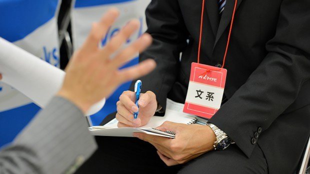 メモとペンを手に企業のPRを熱心に聞く就活生=関口純撮影