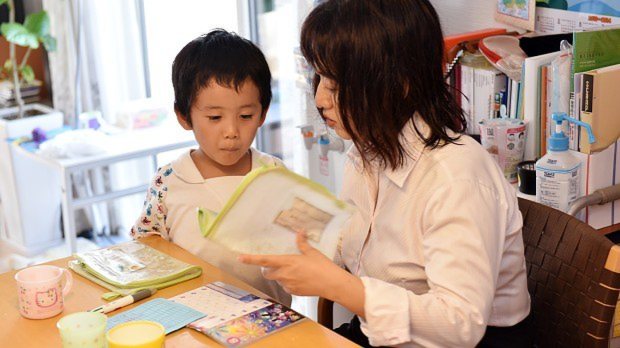 働きながら子供を育てる女性。保育園の連絡帳を準備中=埼玉県鶴ヶ島市で2015年8月4日、関口純撮影