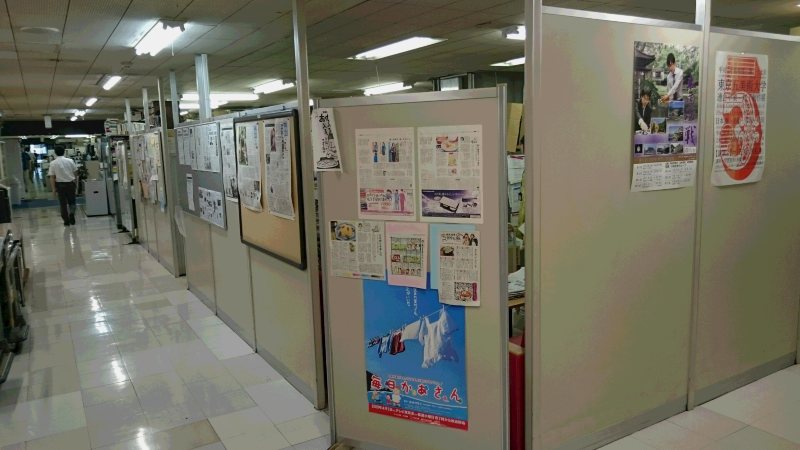 生活報道部の「入り口」。右手奥に通路が続き、そちらからも部に出入りできるのですが、多くの社員がこのすきまから出入りします。つられて見学者の方もすきまから部をのぞいて行かれます=2015年8月、山科武司撮影