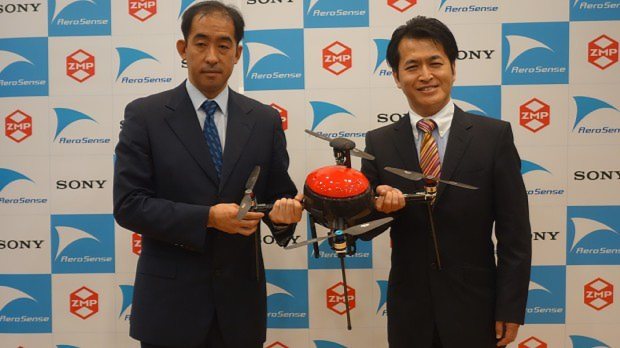 エアロセンス開発のドローンを持つ谷口恒ZMP社長(右)=2015年8月24日、片平知宏撮影