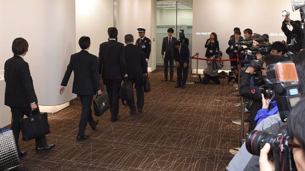 大勢の報道陣が集まる中、旭化成建材本社に立入検査に入る国交省の職員ら=東京都千代田区で2015年11月2日