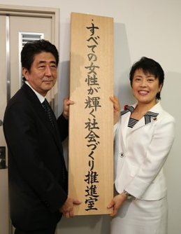 看板をかける安倍晋三首相(左)と有村治子女性活躍担当相(当時)=東京都千代田区の内閣府で2014年10月