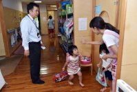 父親のお迎えに喜び、先生とバイバイをする子供＝埼玉県鶴ヶ島市のかこのこ保育園で、関口純撮影