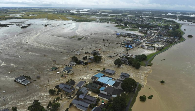 大雨の影響で鬼怒川(右)の堤防が決壊し、流れこんだ濁流にのまれた茨城県常総市の住宅街=2015年9月10日、本社ヘリから