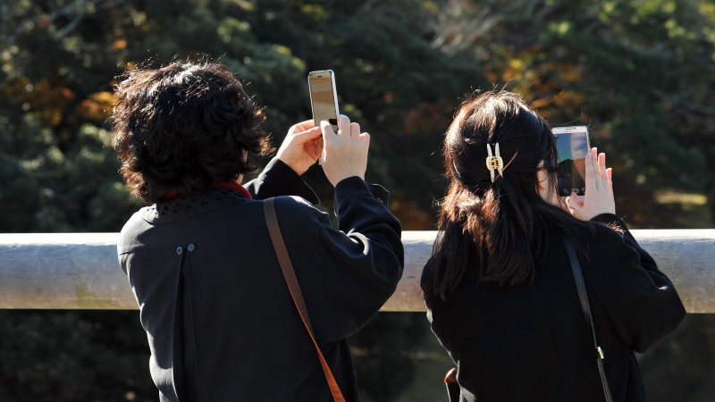 携帯電話のある風景=2015年12月7日、関口純撮影