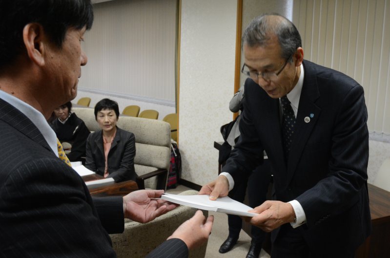 第三者委の大谷委員長(左)から調査報告書を受け取る江上町長=長崎市栄町の長崎県市町村会館で2016年1月6日午後1時35分ごろ、小畑英介撮影