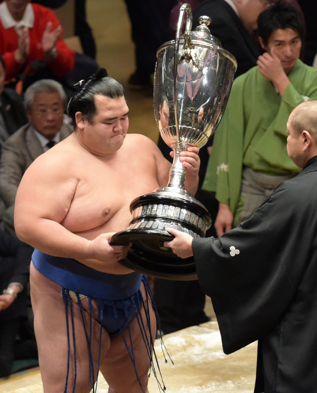 大相撲初場所千秋楽で初優勝し、八角理事長(右)から賜杯を受け取る琴奨菊=東京・両国国技館で2016年1月24日、内藤絵美撮影