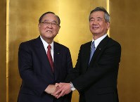 記者会見後、握手する御手洗冨士夫氏（左）と真栄田雅也氏＝東京都内のホテルで２０１６年１月２７日、小出洋平撮影