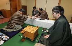 封じ手を立会の木村一基八段に手渡す羽生名人(左)。右は郷田王将=栃木県大田原市のホテル花月で2016年2月4日午後6時5分