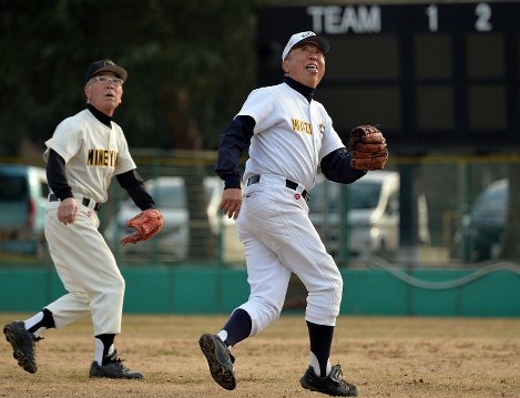 グラウンドで懸命にボールを追う松本友夫さん（右）＝京都府亀岡市で、小松雄介撮影