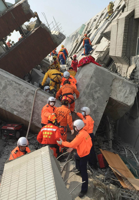 地震で崩壊したマンションで救出作業にあたる警察、消防の隊員たち=台湾南部の台南市で2016年2月6日、鈴木玲子撮影