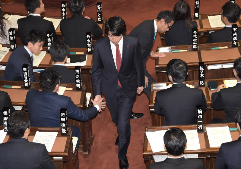 衆院本会議で議員辞職願が承認され、同僚議員と握手して議場を後にする自民党の宮崎謙介氏(中央)=国会内で2016年2月16日午後1時3分、藤井太郎撮影