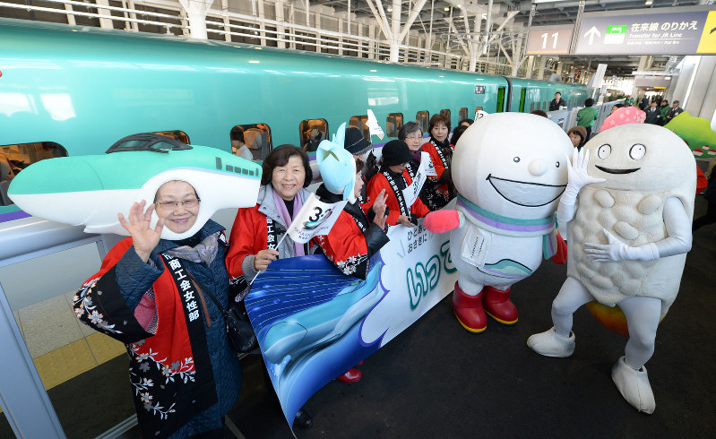 試乗会で歓迎ムードを高める商工会関係者や新幹線のマスコットキャラクター=北海道北斗市の新函館北斗駅で、手塚耕一郎撮影