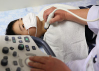 甲状腺の超音波検査を受ける子供。県の調査でも同様の検査が行われている＝福島県平田村の「ひらた中央クリニック」で、佐々木順一撮影