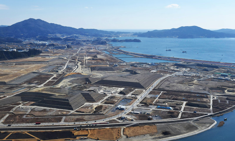 被災地で最大級のかさ上げ工事が進む陸前高田市の旧市街地。土砂で地盤を7〜10メートル上げる。大型商業施設などが出店して商店街を再生する計画が進む=2016年2月19日、本社ヘリから喜屋武真之介撮影