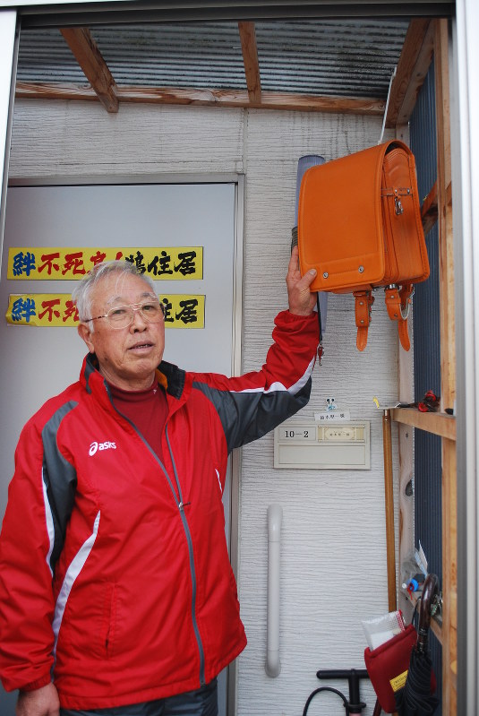 鈴木堅一さんの仮設住宅の玄関先に掛けられた理子さんの遺品のランドセル。出入りするとき「じいじは頑張るよ」などと語り掛ける=岩手県釜石市栗林町で、中田博維撮影