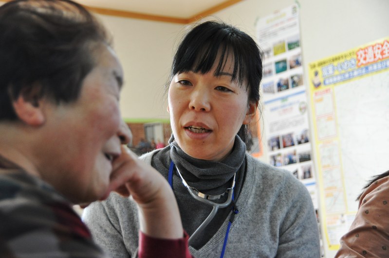 仮設住宅集会所で住民と会話を交わしながら健康診断する藤田奈緒美さん(右)=福島県いわき市で