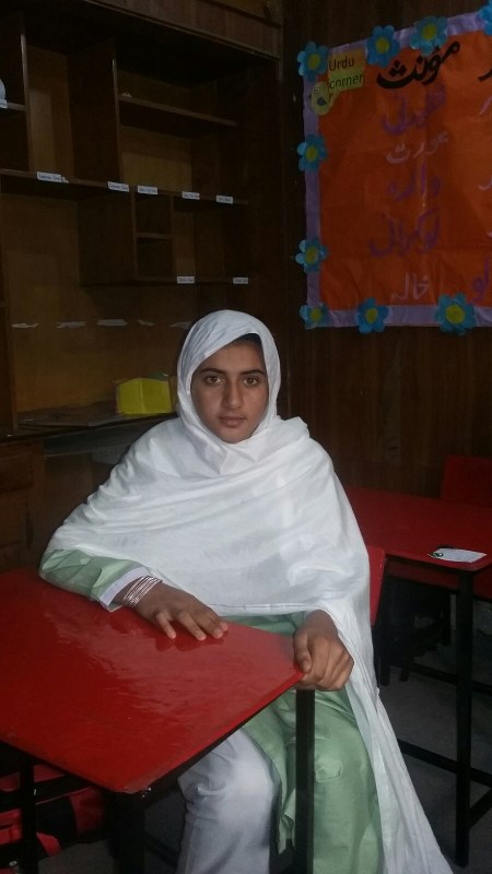 パキスタン北西部の学校で、教室の椅子に座るナビラ・レフマンさん=同校提供