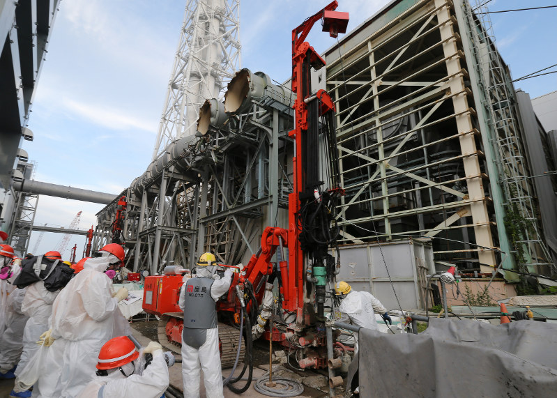東京電力福島第1原発4号機南側で行われている凍土遮水壁の設置工事=2014年7月8日午後6時14分(代表撮影)
