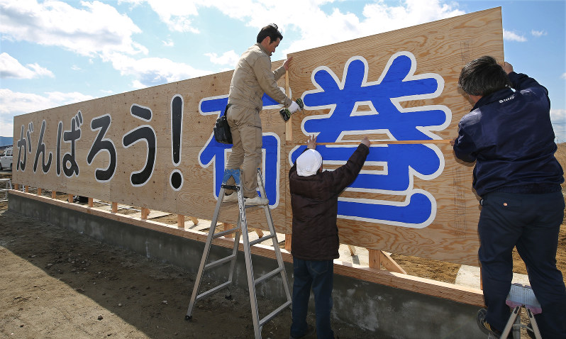 新しく制作した「がんばろう!石巻」の看板を設置する人たち=宮城県石巻市で2016年4月11日午前9時48分、佐々木順一撮影