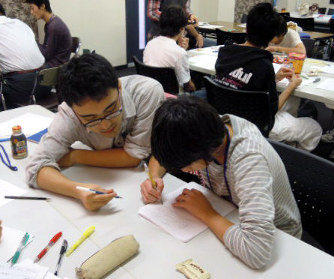 貧困家庭の中学生を対象にした無料の学習会で勉強を教えるボランティアの大学生(左)=キッズドア提供
