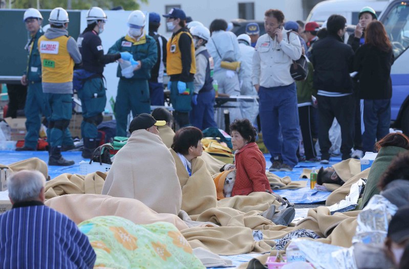 町役場前で毛布にくるまりながら夜を明かした避難者たち=熊本県益城町で2016年4月16日午前6時15分、宮武祐希撮影
