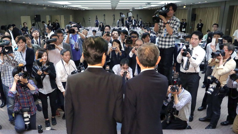 報道陣に囲まれる東芝の綱川智・次期社長(右)と志賀重範・次期会長=2016年5月6日、宮武祐希撮影