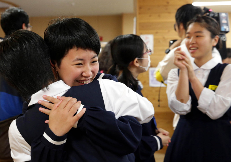 25日ぶりに学校が再開され、友人と抱き合って喜ぶ中学生=熊本県益城町で2016年5月9日午前8時51分、幾島健太郎撮影