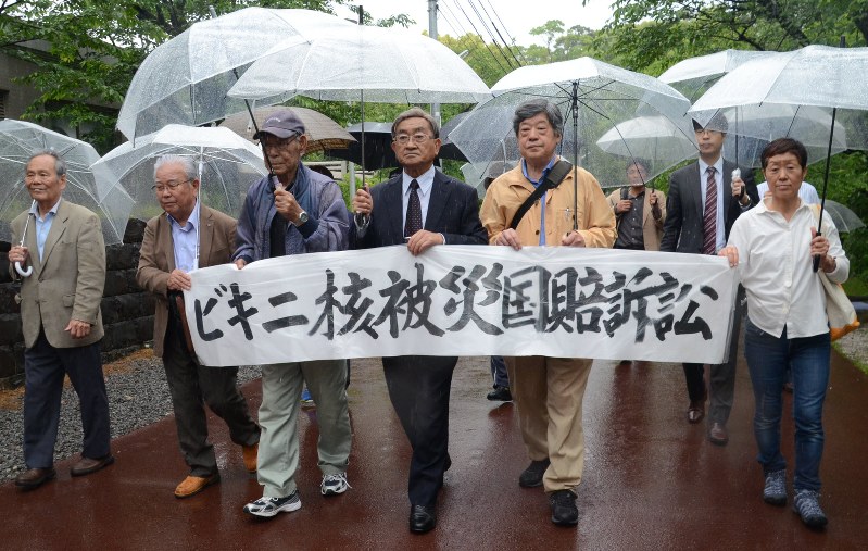 ビキニ水爆実験での国の責任を問うため、横断幕を掲げて高知地裁に入る原告団ら=高知市丸ノ内1で2016年5月9日午後1時2分、岩間理紀撮影
