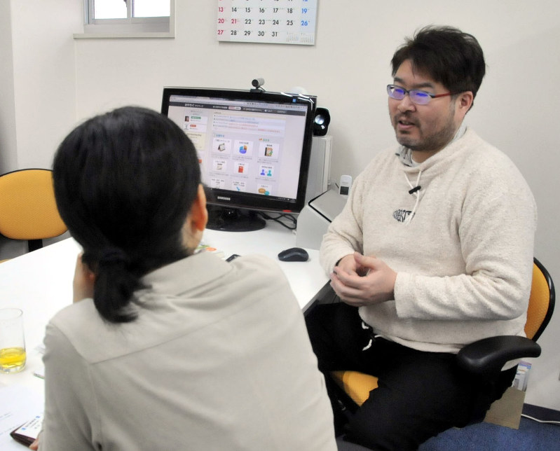 遠距離介護を経験し、「おやろぐ」を運営する横井孝治さん(右)と話すおやろぐ利用者=大阪市都島区で、西田真季子撮影