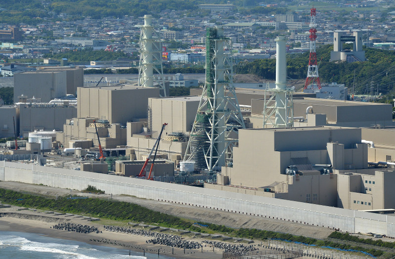 停止から5年を迎える浜岡原発。海抜22メートルの防波壁に囲まれている。奥は御前崎市街=静岡県御前崎市で2016年5月12日、本社ヘリから丸山博撮影