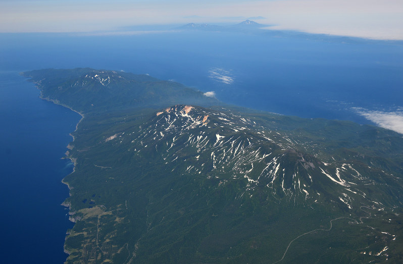 上空から眺めた北海道・知床半島。左奥が知床岬。右奥は国後島=2015年6月29日、本社機「希望」から手塚耕一郎撮影