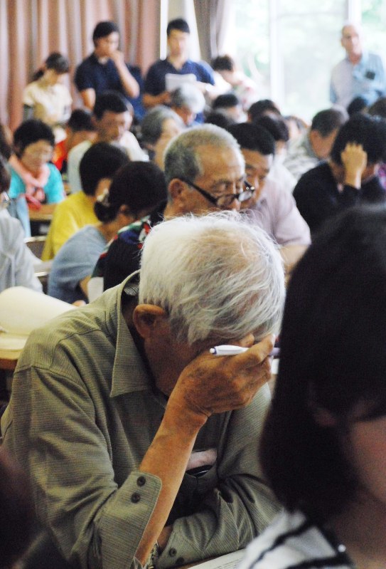 仮設住宅入居説明会で、疲れた様子で熊本市の説明を聞く被災者ら=熊本市南区で2016年5月28日午前10時6分、中里顕撮影