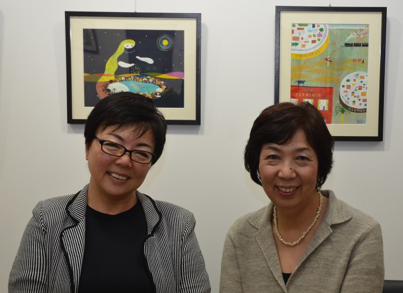 イラストレーターの乾真徳氏が描いた絵本の原画を背にする原作者の福田英子さん(左)と製作委員会代表の田口淳子さん=東京都中央区銀座の「朝日画廊」で