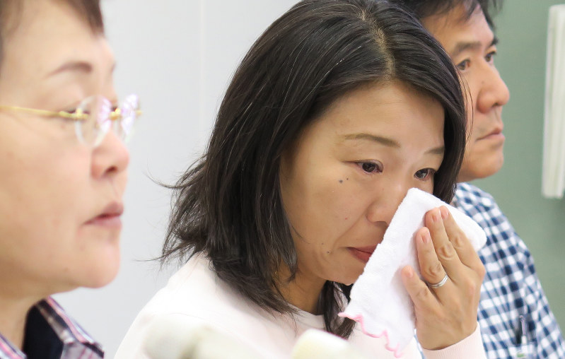 ヘイトスピーチデモを禁じる仮処分が決まったことを受け、会見で涙をぬぐう被害者の崔江以子さん(中央)=川崎市川崎区で2016年6月2日午後3時55分、後藤由耶撮影