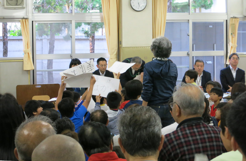 住民説明会では、子どもたちが反対をアピールする紙を掲げて声を上げる場面もあった=東京都杉並区で