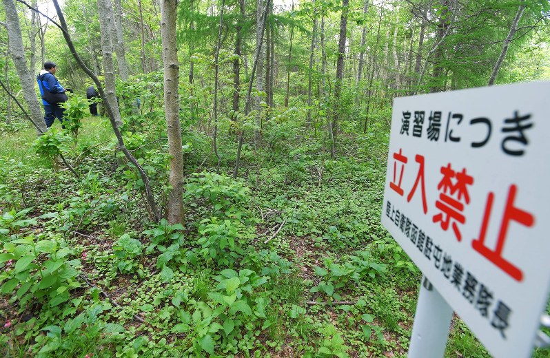 男児が行方不明になった方角の自衛隊演習場の境界付近。長期間使用していないゲートなどがあり、周辺は草木で覆われている=北海道鹿部町で2016年6月3日午後1時40分、手塚耕一郎撮影