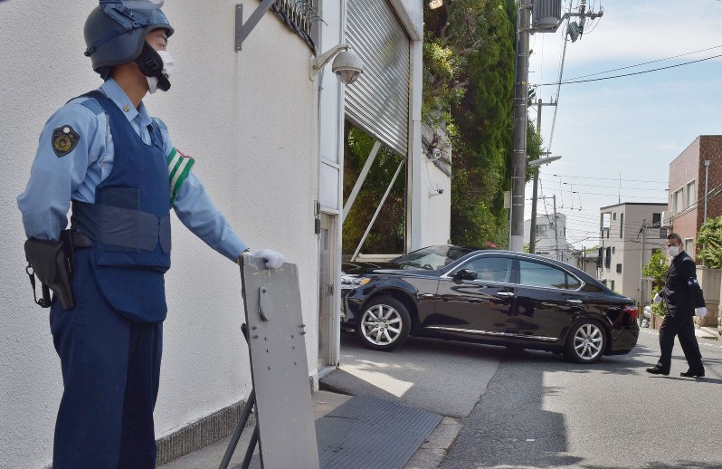 警察官が警戒する中、山口組総本部に入る車両=神戸市灘区で2016年6月6日午前9時55分