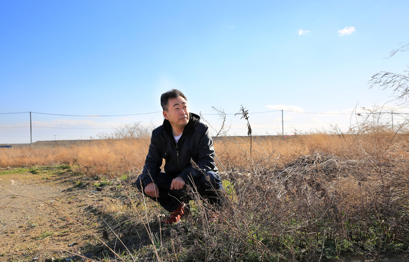 「仁美には俺たちが笑って生きている姿を見せ続ける。だっていつも一緒に『生きて』いるんだからって」。妻仁美さんを探し続けた自宅跡で岡島由隆さんは自分に言い聞かせるように言った=宮城県石巻市で2016年3月21日、梅村直承撮影