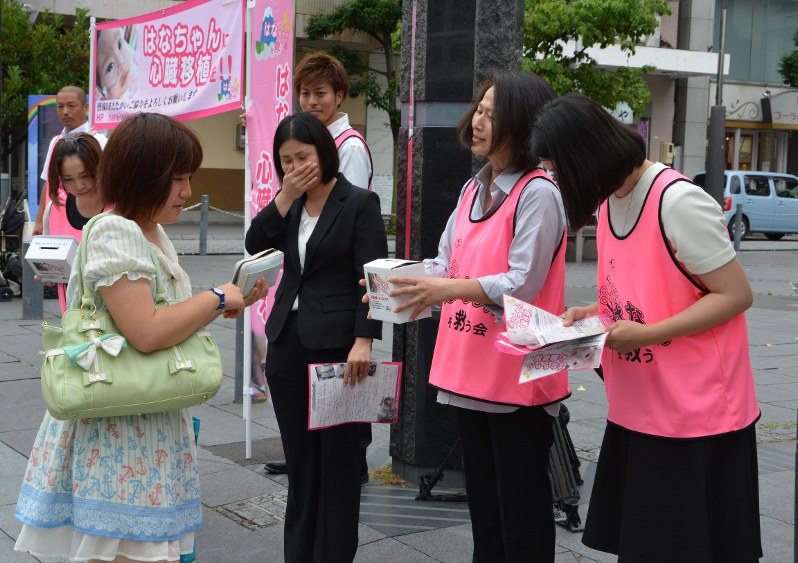 静岡市役所前で募金活動をする花愛ちゃんの母雅子さん(右から3人目)ら=静岡市葵区で