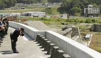 岩手県宮古市田老地区の津波防潮堤で、海に向かって黙礼される皇太子ご夫妻。中央奥は高台の三王団地。右奥はたろう観光ホテル＝２０１６年６月２１日午前９時３１分（代表撮影）