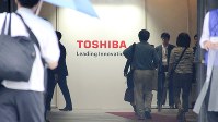 雨がぱらつく中、定時株主総会の会場に入る東芝の株主ら＝２０１６年６月２２日撮影