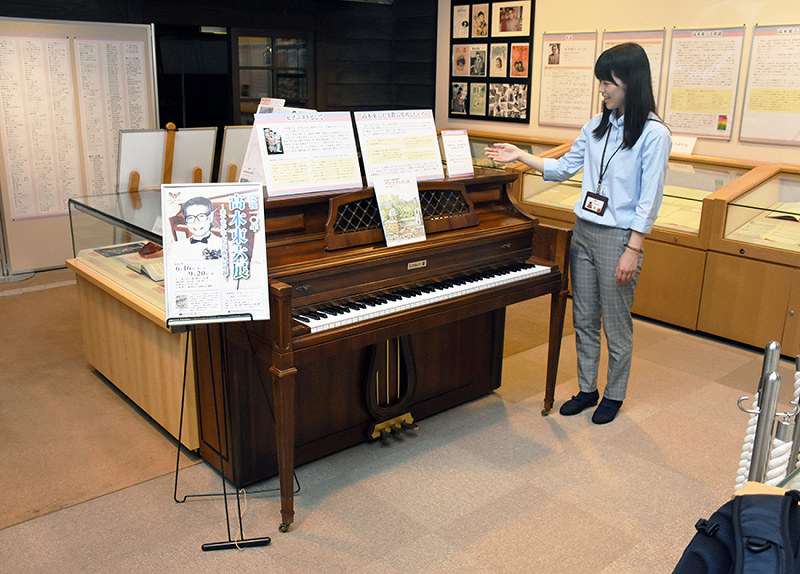 高木東六さんが生前使用していたピアノを紹介するわらべ館職員=鳥取市のわらべ館で、園部仁史撮影
