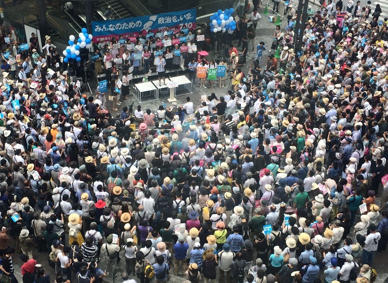 参院選公示を前に、合同街頭演説会で学生の訴えに聴き入る聴衆。家庭内では……=東京・有楽町で19日、奥村隆撮影