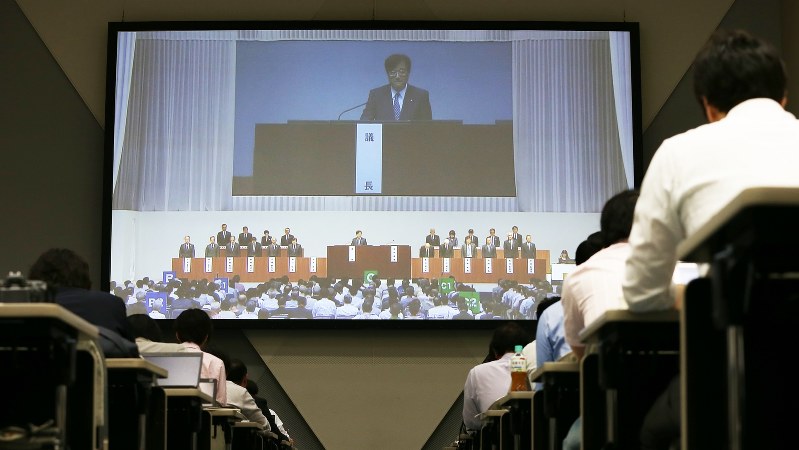 三菱自動車の定時株主総会が始まり、スクリーンに映し出される益子修会長=2016年6月24日、小出洋平撮影